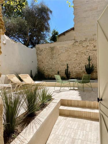 - une terrasse avec 2 chaises, une table et des chaises dans l'établissement La Maison du Puisatier • Centre historique • Piscine chauffée •Jardin, à Uzès
