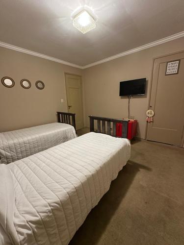 a bedroom with two beds and a flat screen tv at El lapacho 3 in Santiago del Estero