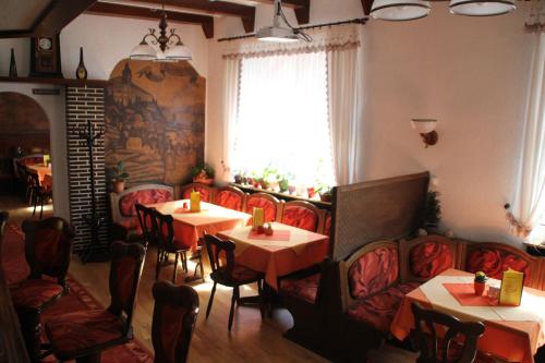 a restaurant with tables and chairs and a window at Hotel Thüringer Hof in Rudolstadt