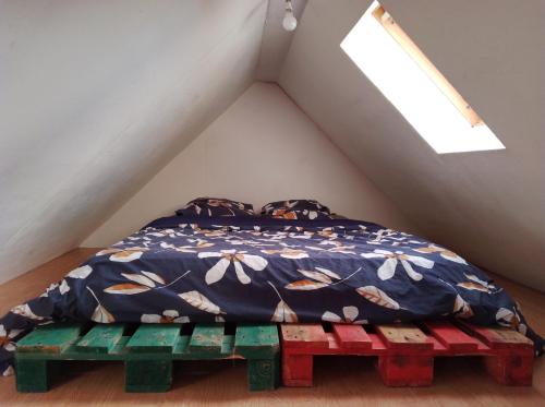 - une chambre avec un lit et un banc en bois dans l'établissement Chez Titi, à Mulhouse