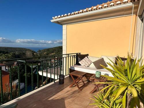 a balcony with a couch sitting on a balconysenalsenalsenalsenalsenal at São Julião Beach in Carvoeira