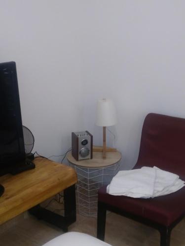 un salon avec une chaise, une table et un haut-parleur dans l'établissement Couche-tard, au Bourget