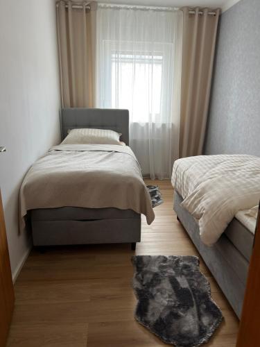 a bedroom with two beds and a window at Ferienwohnung Ferlach TOP1 in Ferlach