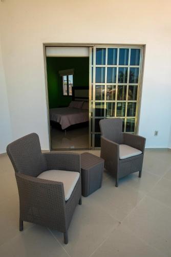 a room with two chairs and a bed and a mirror at Large Villa private pool, 1 block from the beach in Chicxulub