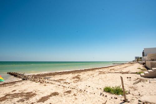 a beach with a row of chairs on it at Large Villa private pool, 1 block from the beach in Chicxulub