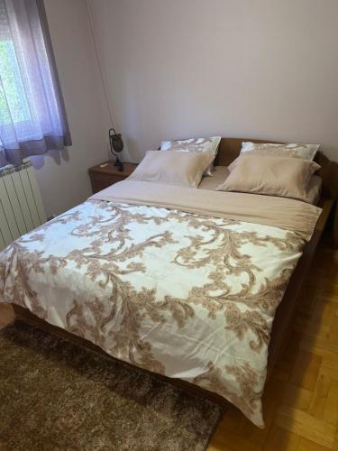 a bed in a bedroom with a blanket on it at Gold Lux in Podgorica
