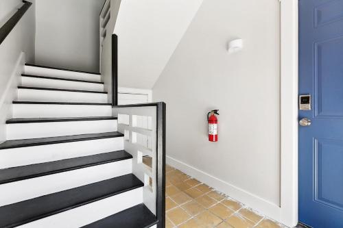 a staircase with a fire hydrant next to a blue door at StayAE Downtown - 1BR Apartment, Ground Floor in Baton Rouge