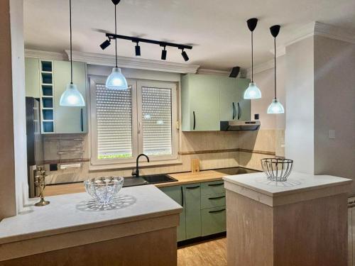 a kitchen with green cabinets and pendant lights at Gold Lux in Podgorica