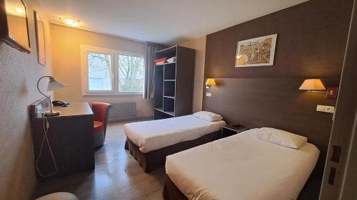 a hotel room with two beds and a window at Hotel Val Vert in Pouilly-en-Auxois