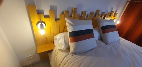 a bedroom with a bed with a wooden headboard and pillows at Le petit coin caché in Montreuil-Bellay