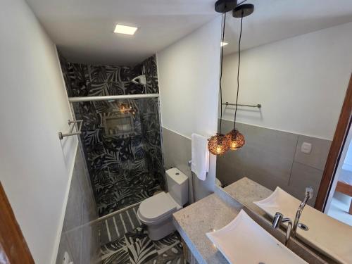 a bathroom with a toilet and a sink and a mirror at Casa Ilhéus in Ilhéus