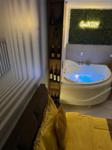 a bathroom with a tub with a sign on the wall at SpaNish apartman 4 in Niš