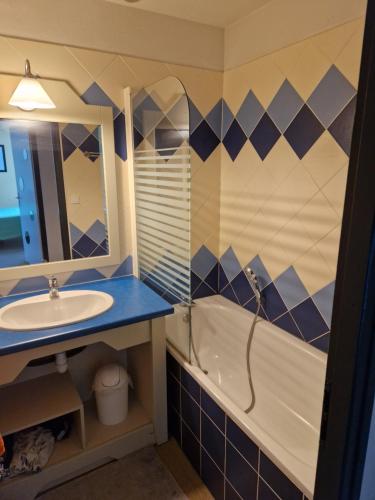 a bathroom with a sink and a tub and a mirror at Grand T3 - Terrasse les pieds dans l'eau - Climatisation in Saint-Raphaël