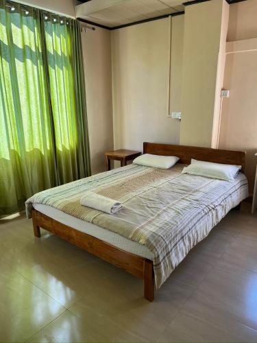 a bedroom with a bed and a large window at Zaras Cottage in Āīzawl