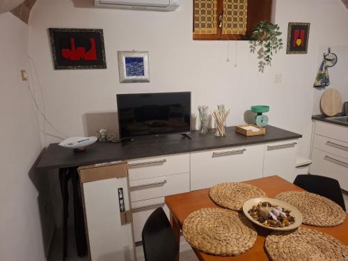 a kitchen with a table with chairs and a television at Casa San Giorgio in Giglio Porto