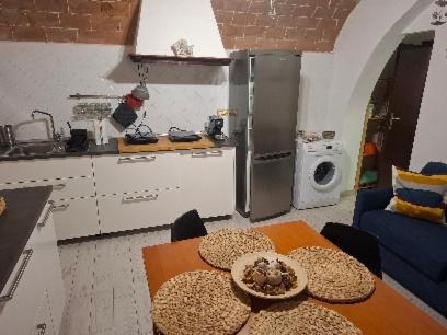 a kitchen with a table and a kitchen with a refrigerator at Casa San Giorgio in Giglio Porto