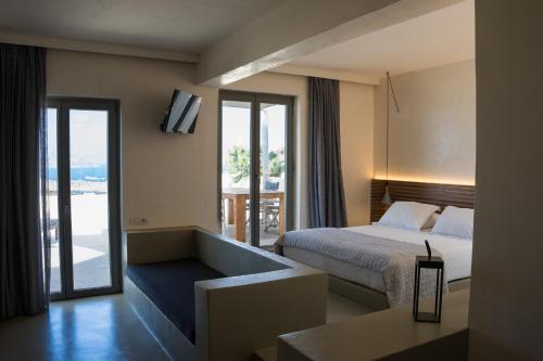 a hotel room with a bed and a balcony at Wabi Luxury Suites & Maisonettes Ios in Ios Chora