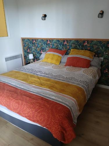 Elle comprend un grand lit avec des oreillers colorés. dans l'établissement T3 à 10 minutes de l'aéroport de Bastia Poretta, à Biguglia