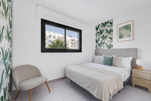 a bedroom with a bed and a chair and a window at Valentino Golf II Luxury in Orihuela