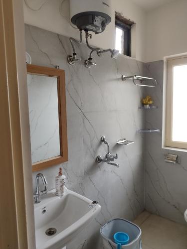 a bathroom with a sink and a mirror at Sanchi's Homestay 2BHK in Bhowāli