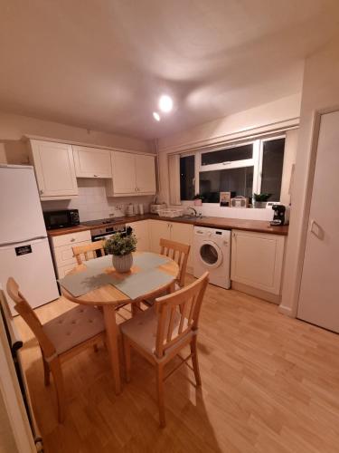 a kitchen with a table and chairs and a white refrigerator at Blossom House in Woodbridge