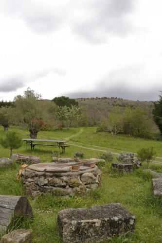 a picnic table and a bench in a field at Jolie cabane avec vue magique sur la montagne in Bugarach