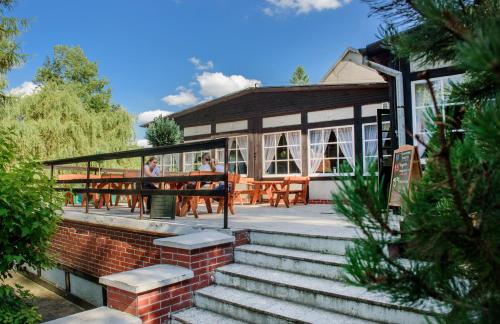 a building with tables and benches in front of it at Ośrodek Wypoczynkowy Kołatek in Olsztynek
