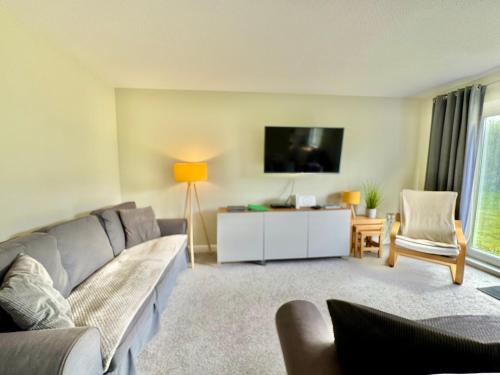 a living room with a couch and a flat screen tv at 7 Isallt Lodges-3 bed-Ground Floor-Outside seating in Trearddur