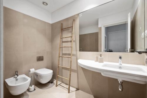 a bathroom with a sink and a toilet and a mirror at SeaSide Serenity in Funchal