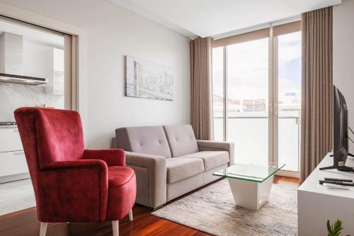 a living room with a couch and a chair at SeaSide Serenity in Funchal