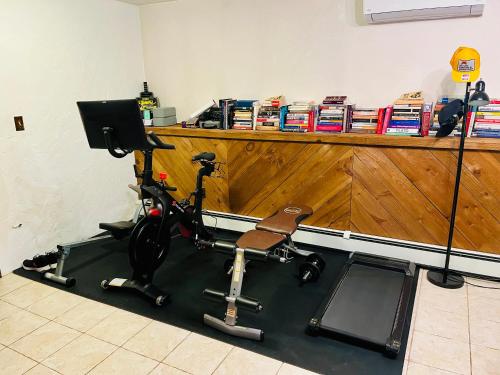 a room with a gym with a bike on a treadmill at Cheerful, sun-kissed room with workstation in Revere