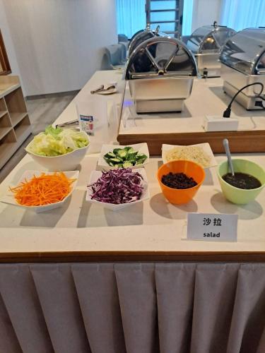 a table with bowls of vegetables on a counter at Champion Hotel in Taipei