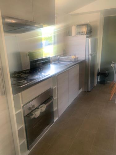 une cuisine avec une cuisinière et un réfrigérateur dans l'établissement Mobil Home Lège Cap ferret bassin, à Lège-Cap-Ferret