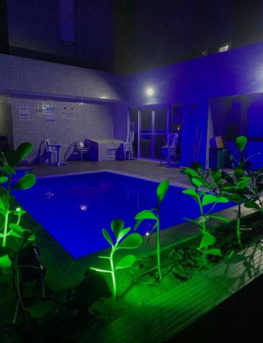 a room with a swimming pool at night at Apartamento Temporada Praias Litoral sul João Pessoa in João Pessoa