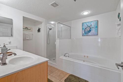 a bathroom with a tub and a sink and a shower at Coastal 3-bed 2-bath Condo-new Smyrna Beach Fl in New Smyrna Beach