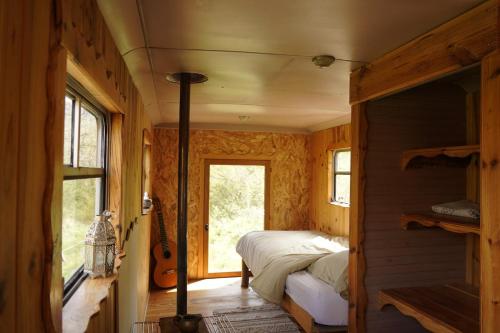 - une chambre avec un lit et une guitare dans l'établissement Bus vintage pour retraite en solo à Bugarach, à Bugarach
