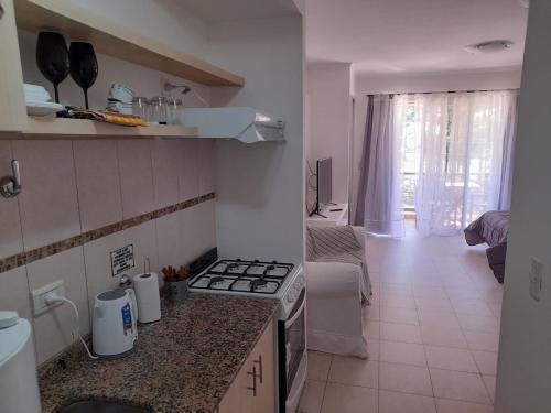 cocina pequeña con fogones y sala de estar. en Puerto Termas, en Colón