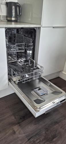 an empty dishwasher in a kitchen with its door open at Chalet 174 Glan Gwna Park Caernarfon in Caeathro
