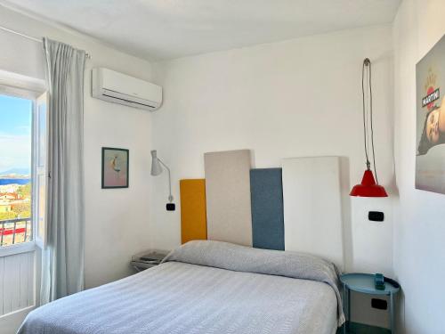 a white bedroom with a bed and a window at Black Market Hotel in Ischia