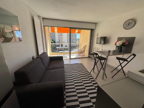 un salon avec un canapé et une table dans l'établissement Appartement dans résidence France, à La Celle-sous-Gouzon