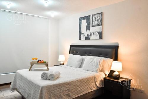 a bedroom with a bed with two towels on it at Infinity Pool Apartment in San Salvador