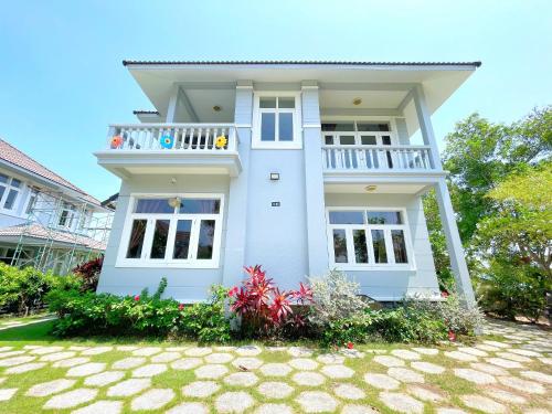a white house with a balcony and a yard at Sealink Mũi Né Villa 5 Phòng - Biệt Thự Nguyễn Dung in Ấp Phú Tịnh (2)