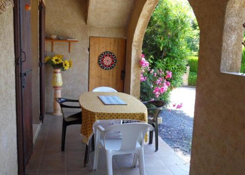 - une table et des chaises sur une terrasse avec une arche dans l'établissement La Cévane, à Chorges