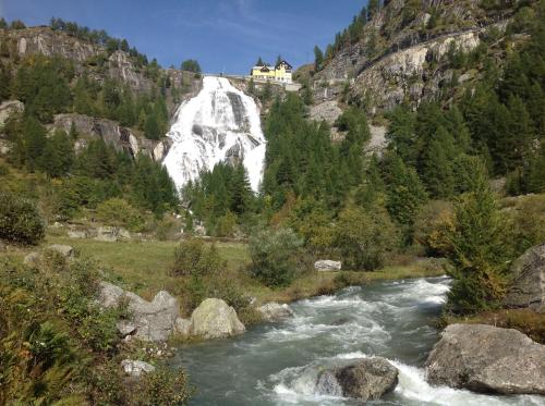 a river with a house on top of a mountain at B&B Monte Giove Formazza in Formazza