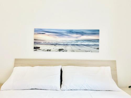 a painting hangs above a bed in a bedroom at Spazioso Appartamento da Maria in Favignana