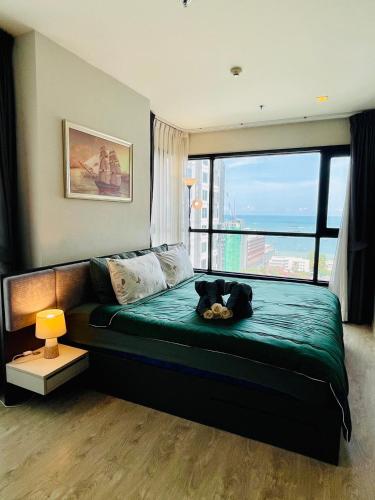 a bedroom with a bed with a cat laying on it at The base Condo luxury 2 bed 2 bathroomby Numam in Pattaya