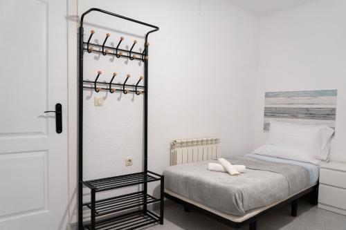 een kleine slaapkamer met een bed en een spiegel bij Moderno Piso Toledano in Toledo