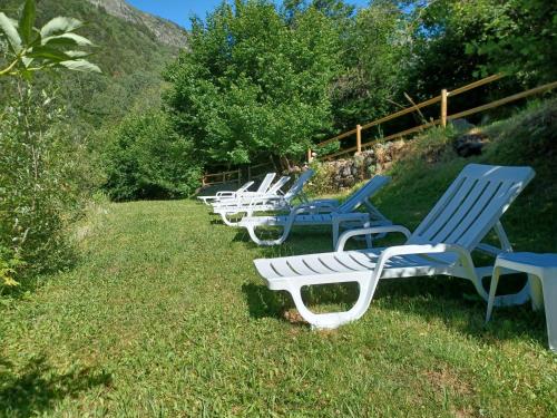 a row of blue and white chairs sitting in the grass at ApartHotel RIALB in El Serrat