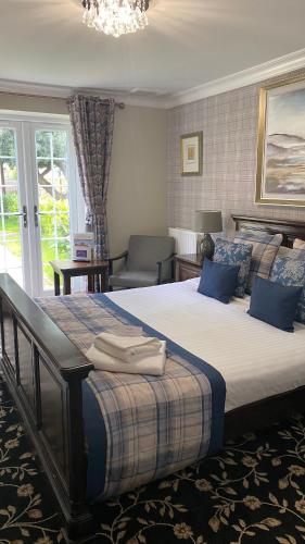 a bedroom with a large bed with blue pillows at Stone House Hotel ‘A Bespoke Hotel’ in Stone
