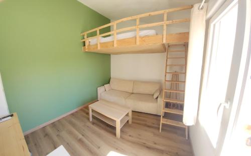 Cette petite chambre comprend des lits superposés et un canapé. dans l'établissement Appartement à 150m de la mer, au Barcarès